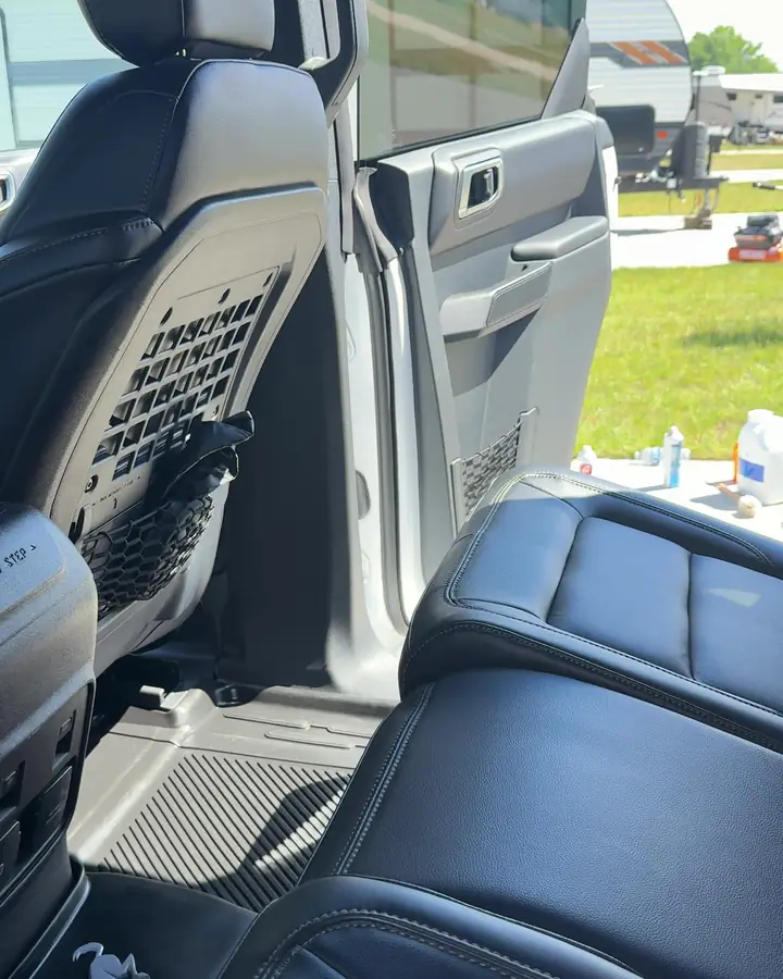 Black leather front seat and door panel of a Ford Bronco after an interior detail