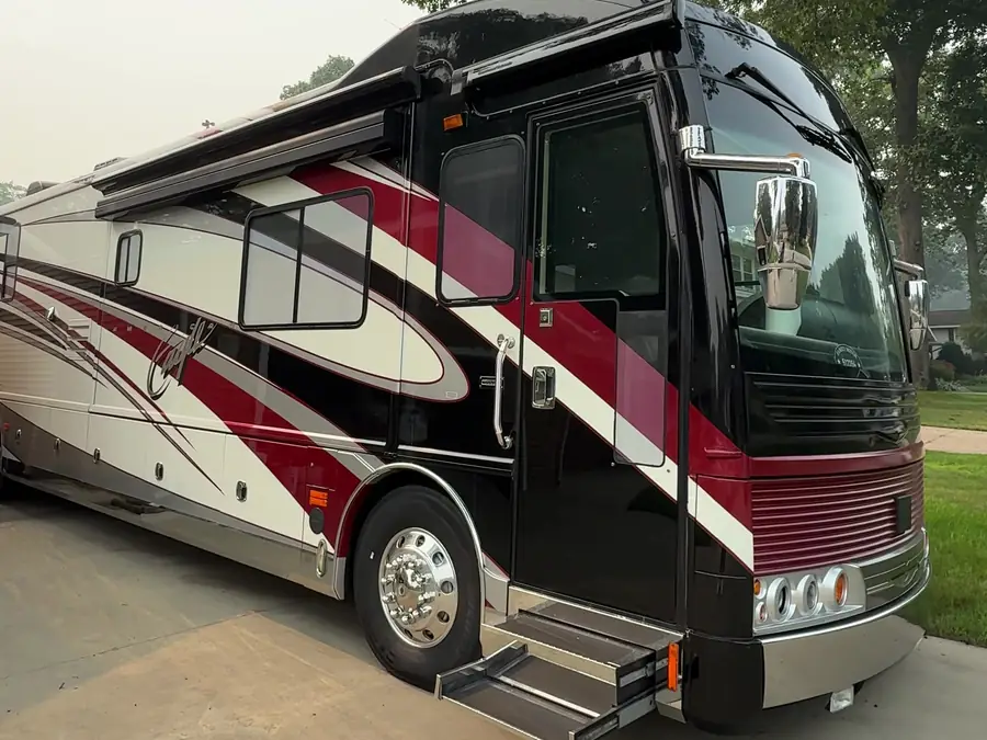 Front of a Class A motorcoach with black, red and cream graphics after an RV detail