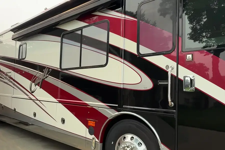Side of a Class A motorcoach with red and black swoosh graphics after an RV detail