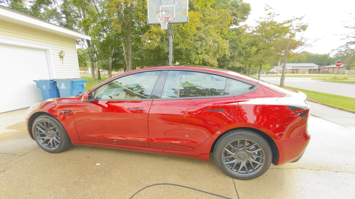 Side view of a red Tesla Model 3 with a deep gloss finish after a 10-year ceramic coating in Grand Haven, MI