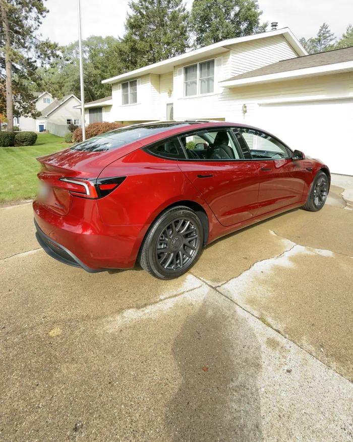 Rear three-quarter view of a red Tesla Model 3 with a glossy finish after ceramic coating in Grand Haven, MI