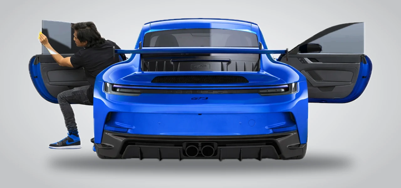 Blue sports car with the doors open while window tint is installed