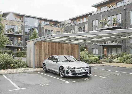 Silver Audi e-tron GT parked under a carport at an apartment complex