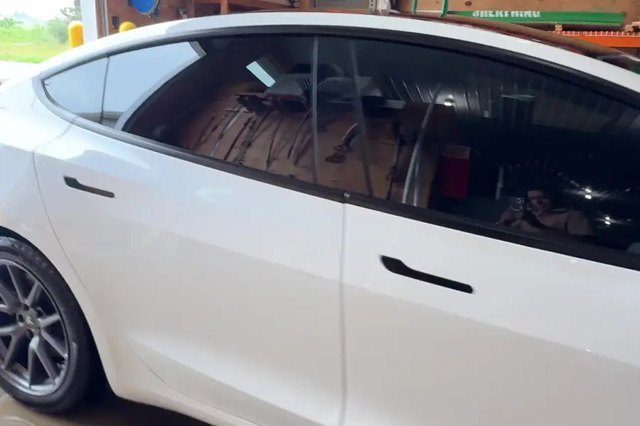 Side of a white Tesla sedan with a clean glossy finish after ceramic coating